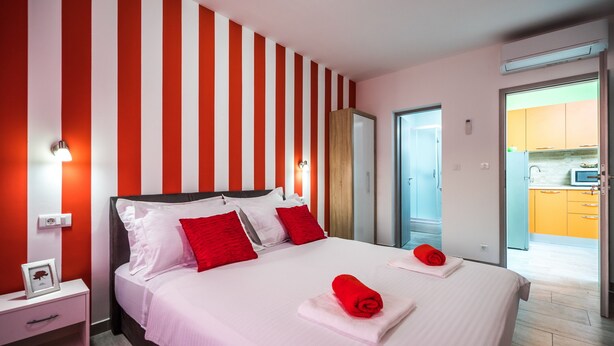 Een hotelkamer met een bed, nachtkastje en uitzicht op de keuken.