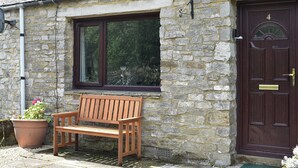 A stone house with a wooden bench outside, a dark brown door, and a window with a white frame. - 2 bedroom accommodation in Horton-in-Ribblesdale, near Settle (Horton-in-Ribblesdale, near Settle)
