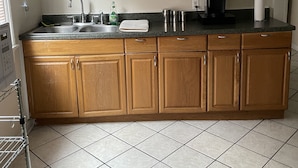 A kitchen with wooden cabinets, a stainless steel sink, and a coffee maker.