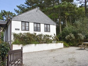 A white cottage with a gravel driveway and a wooden bench. - Prince Croft Cottage - UK12560 (Mount Hawke, near Redruth)