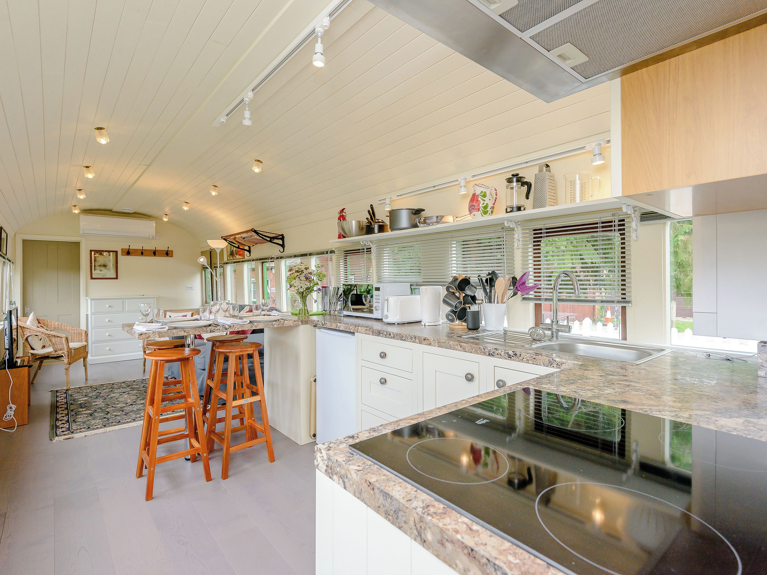 A modern kitchen with white cabinetry, a granite countertop, and a built-in stove.