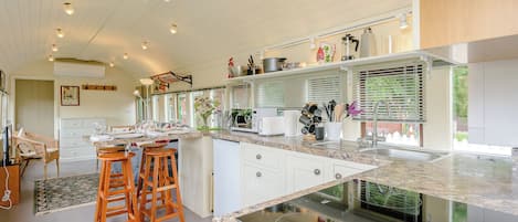A modern kitchen with white cabinetry, a granite countertop, and a built-in stove.