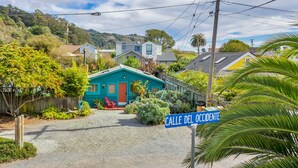 A residential area with a turquoise house, a red door, and a sign reading "Calle Del Accidente". - Cute & Colourful Oceanside Cottage w Garden (Stinson Beach)