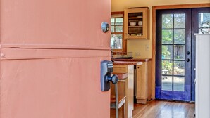 A kitchen with wooden cabinets, a blue door, and a number 7 on the door. - Cute & Colourful Oceanside Cottage w Garden (Stinson Beach)