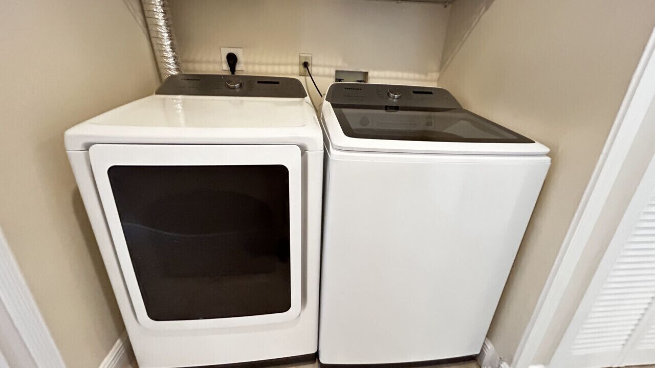 A laundry room with two stacked washer and dryer units.