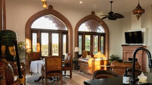 Un salón amplio con chimenea, sofás de cuero y televisor.