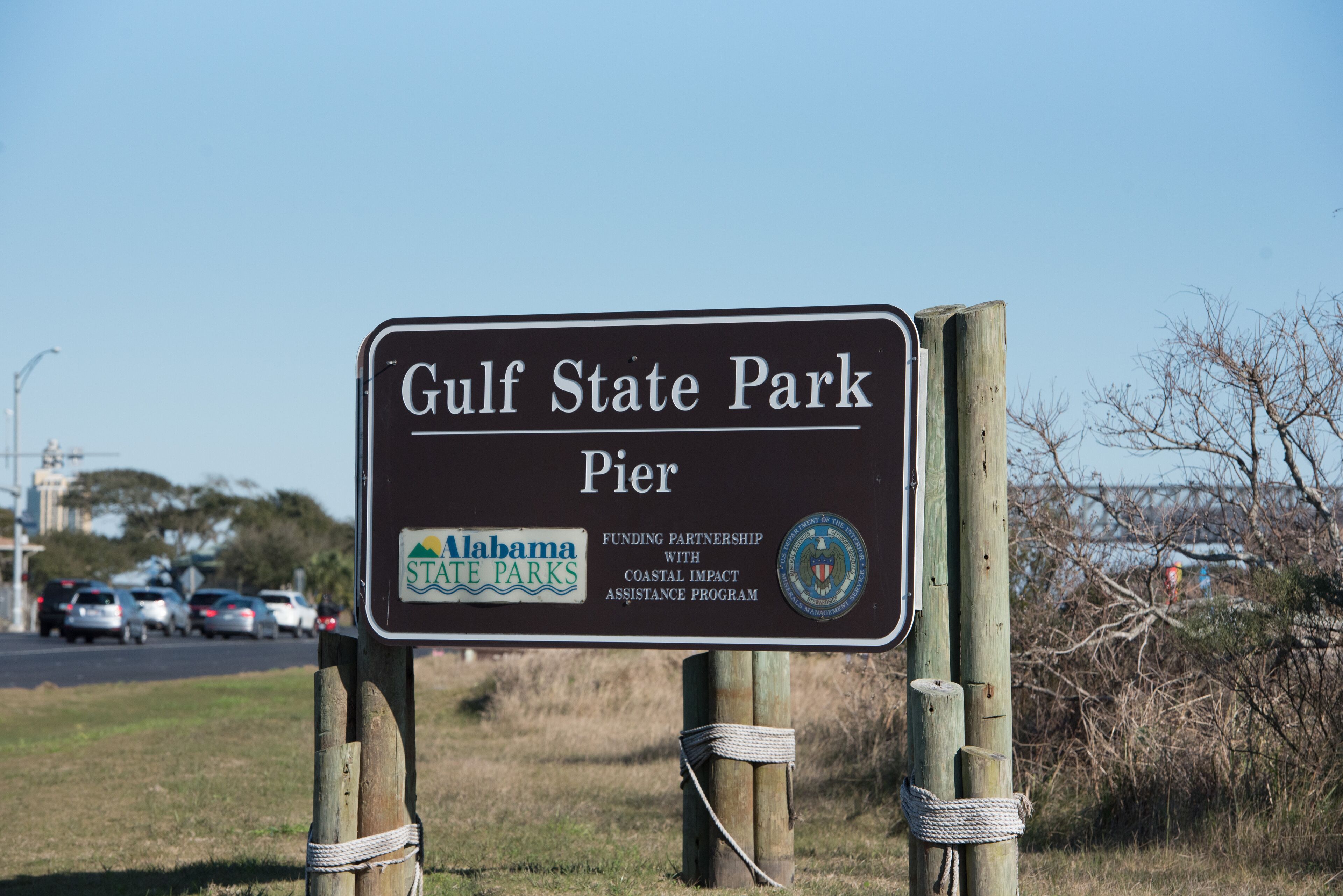 Un panneau indiquant l’entrée du ponton du parc d’État du golfe, et précisant qu’il s’agit d’un projet réalisé en partenariat avec les parcs d’État de l’Alabama et le programme d’aide aux zones côtières.
