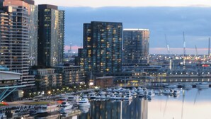 A marina with boats docked, surrounded by high-rise buildings.