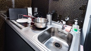 Une cuisine moderne dotée d’appareils électroménagers en acier inoxydable, d’un évier double et d’un pare-feu avec un motif moucheté.
