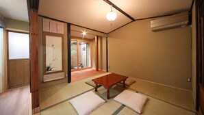 A traditional Japanese room with tatami flooring, a low wooden table, and sliding doors leading to an outdoor area. - Kyomachiya Gion Miyagawatei (Kyoto)