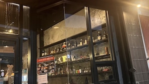A bar with a glass front displaying various bottles and a sign indicating it is a hostel room. - 2Street Hostel at Surathani - Adults Only (Surat Thani)