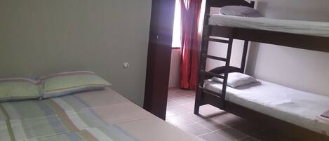 Un dormitorio con una cama litera y una cama individual.