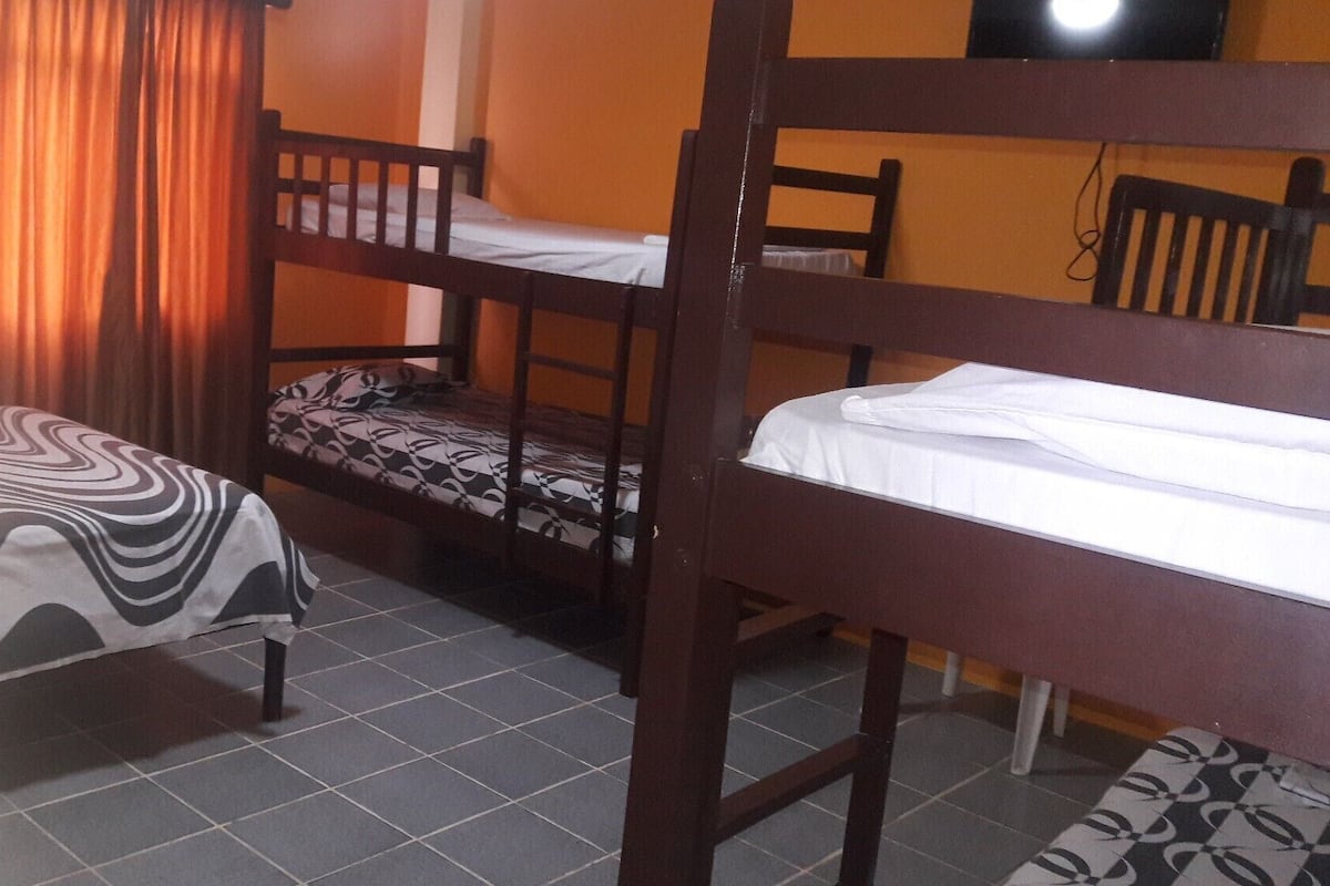 Un dormitorio con literas, una mesita y una silla.