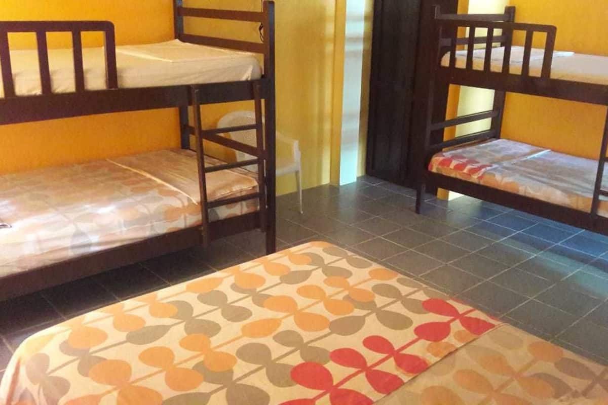 Una habitación con dos literas y una pequeña mesa cubierta con un mantel estampado.