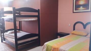 A bunk bed room with a single bed and a small table.