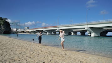 Una playa con un puente al fondo.