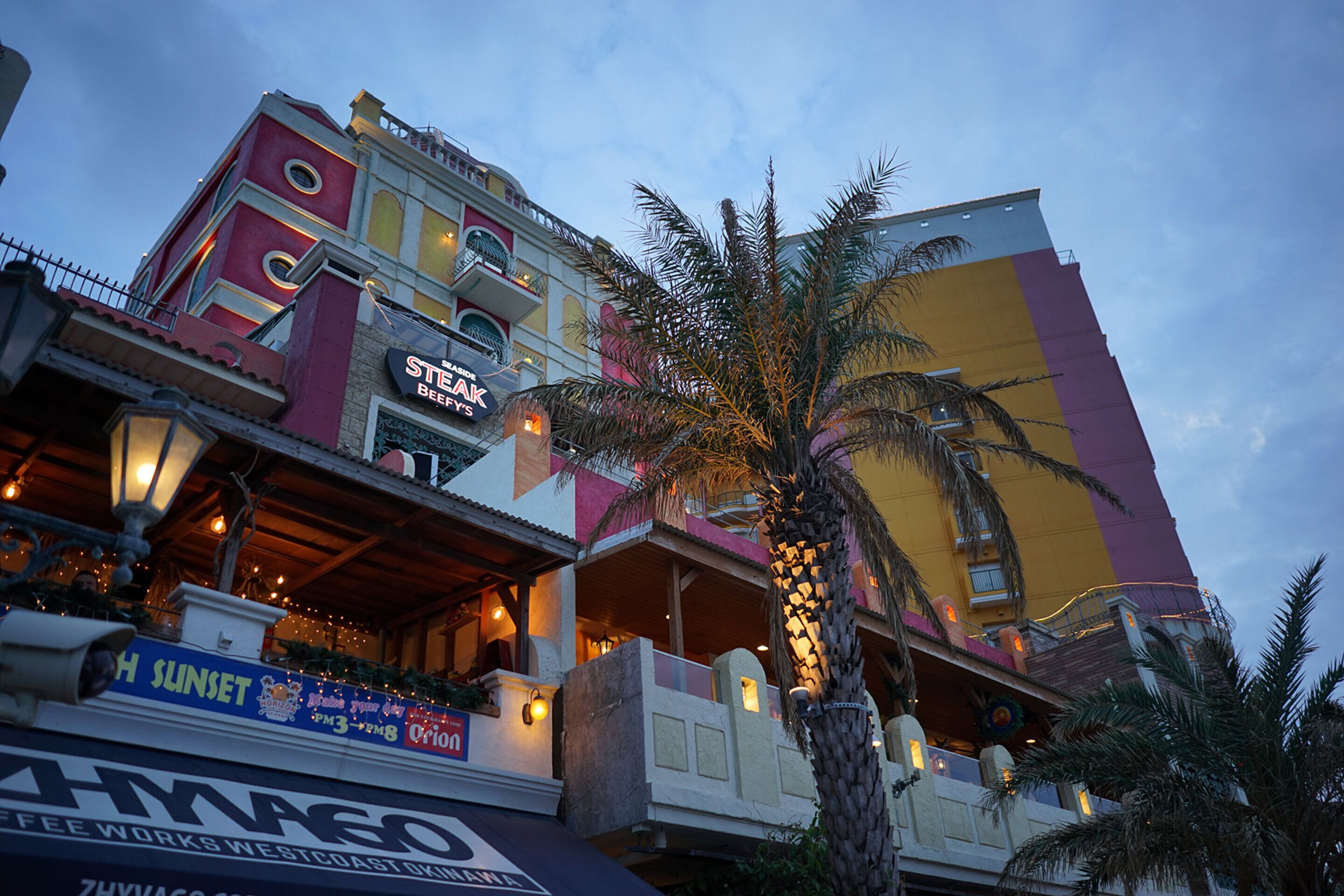Un edificio de varios pisos con un restaurante llamado "Steak & Beer" en la planta baja.