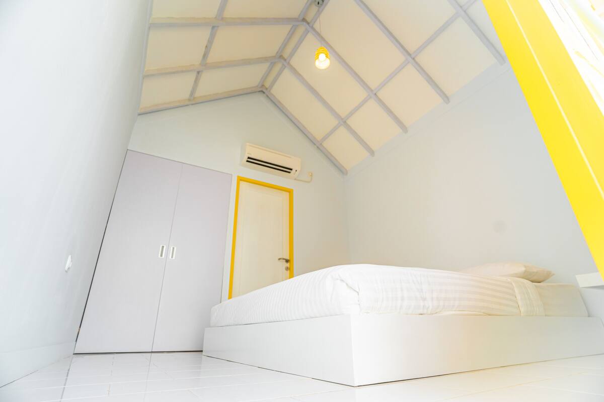 Una camera da letto con un letto, un armadio e una porta.