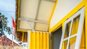 A yellow and white house with a visible window and a door. - Canggu Castle - Hostel (Tibubeneng)