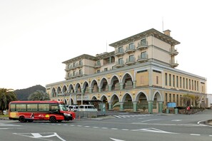 Un grand immeuble à plusieurs étages, de style architectural classique, caractérisé par des fenêtres en arc et des balcons.