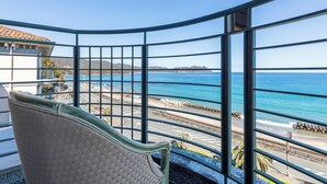 A curved balcony with a view of the ocean and a building with a tiled roof. - Hotel Riviera Shishikui (Kaiyo)