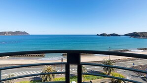 A coastal view from a balcony with a clear sky, a beach, and a road leading to the beach. - Hotel Riviera Shishikui (Kaiyo)
