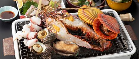 A variety of seafood on a grill, including shrimp, scallops, and lobster.