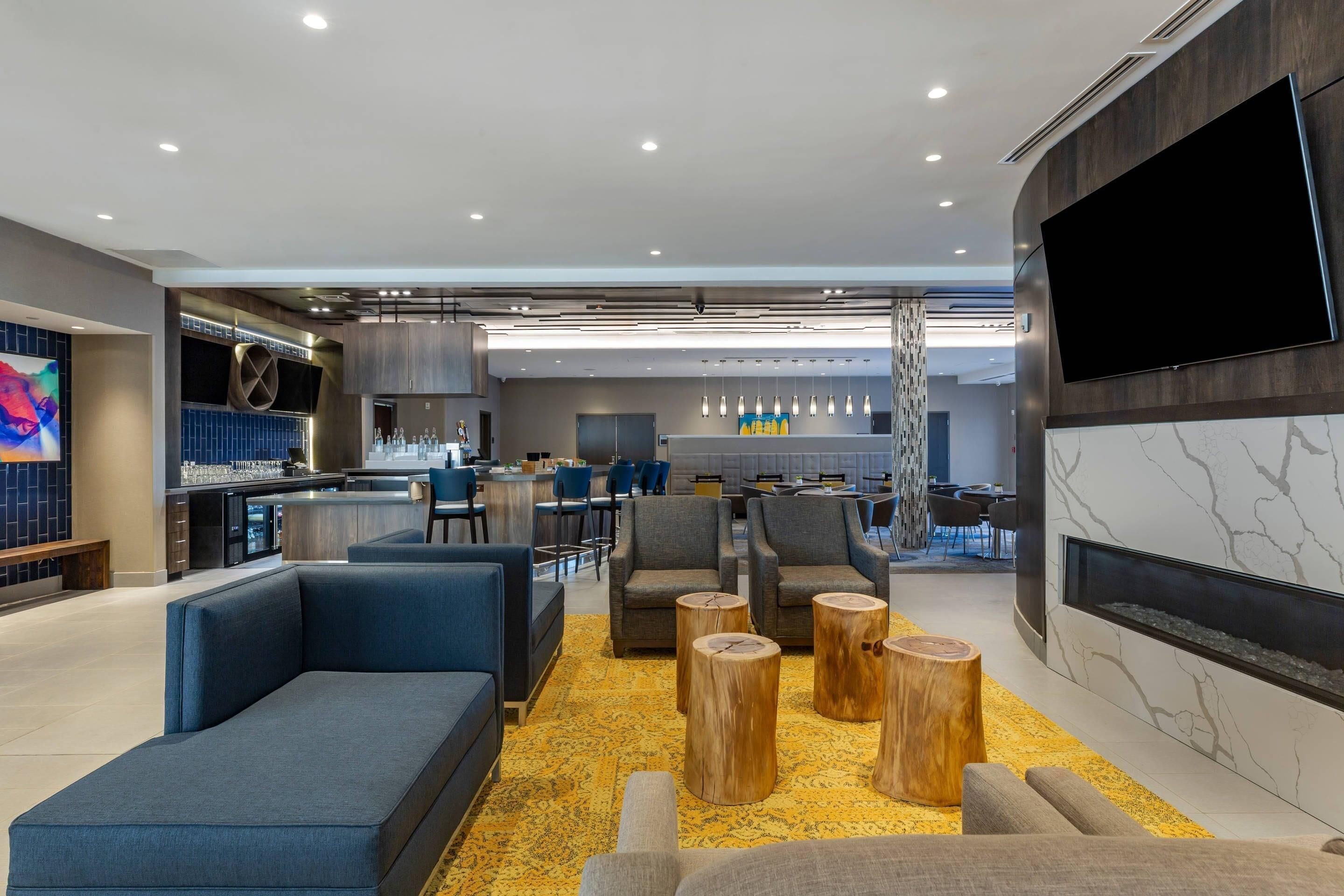 Uma área de estar moderna com sofás, um bar e uma televisão de tela plana.