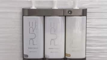 Tres botellas de agua de baño, acondicionador y champú PURE.