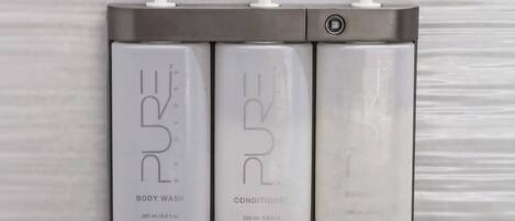 Three bottles of PURE body wash, conditioner, and shampoo.