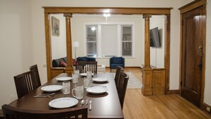 A dining room with a wooden table set for four, flanked by two wooden pillars. - Walk to Wrigley Field/Monthly Discounts Available (Chicago)