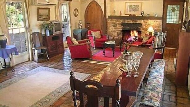 A cozy living room with a fireplace, wooden furniture, and a stone wall. - Bronte Manor, Wuthering Heights ~ min. 4 people - dog friendly (Clare)