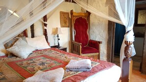 A bedroom with a canopy bed, a red chair, and a wooden nightstand with a lamp. - Bronte Manor, Wuthering Heights ~ min. 4 people - dog friendly (Clare)