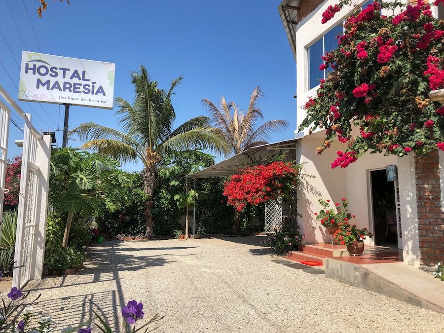 A building with a sign reading "HOSTAL MARESIA" and a gravel driveway leading to the entrance.