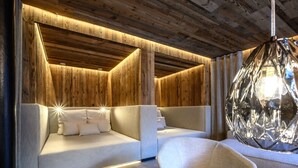 A modern bedroom with a wooden ceiling, a large bed with white bedding, and a hanging light fixture. - Melisande 3 by Interhome (Sölden)