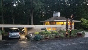 Una casa moderna con garaje, entrada para coches y jardín ajardinado.
