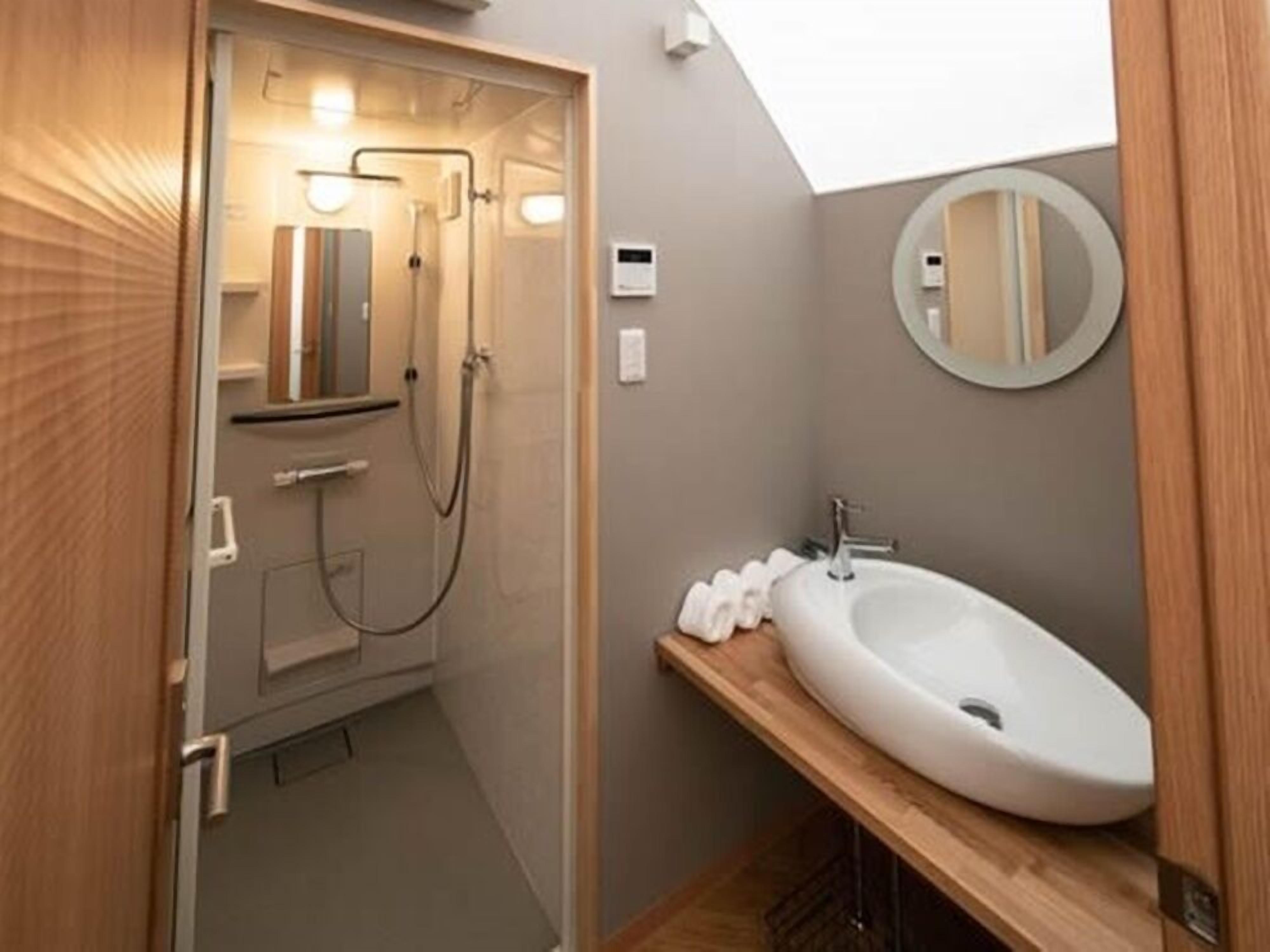 Ein modernes Badezimmer mit Dusche, Waschbecken und Spiegel.