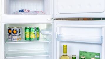 An open refrigerator with beverages and bottles.