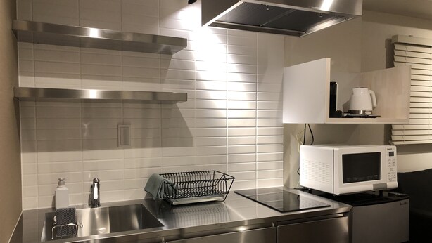 A modern kitchen with stainless steel appliances, a microwave, and a built-in oven. - Condominium MIRAHAKONE (Hakone)