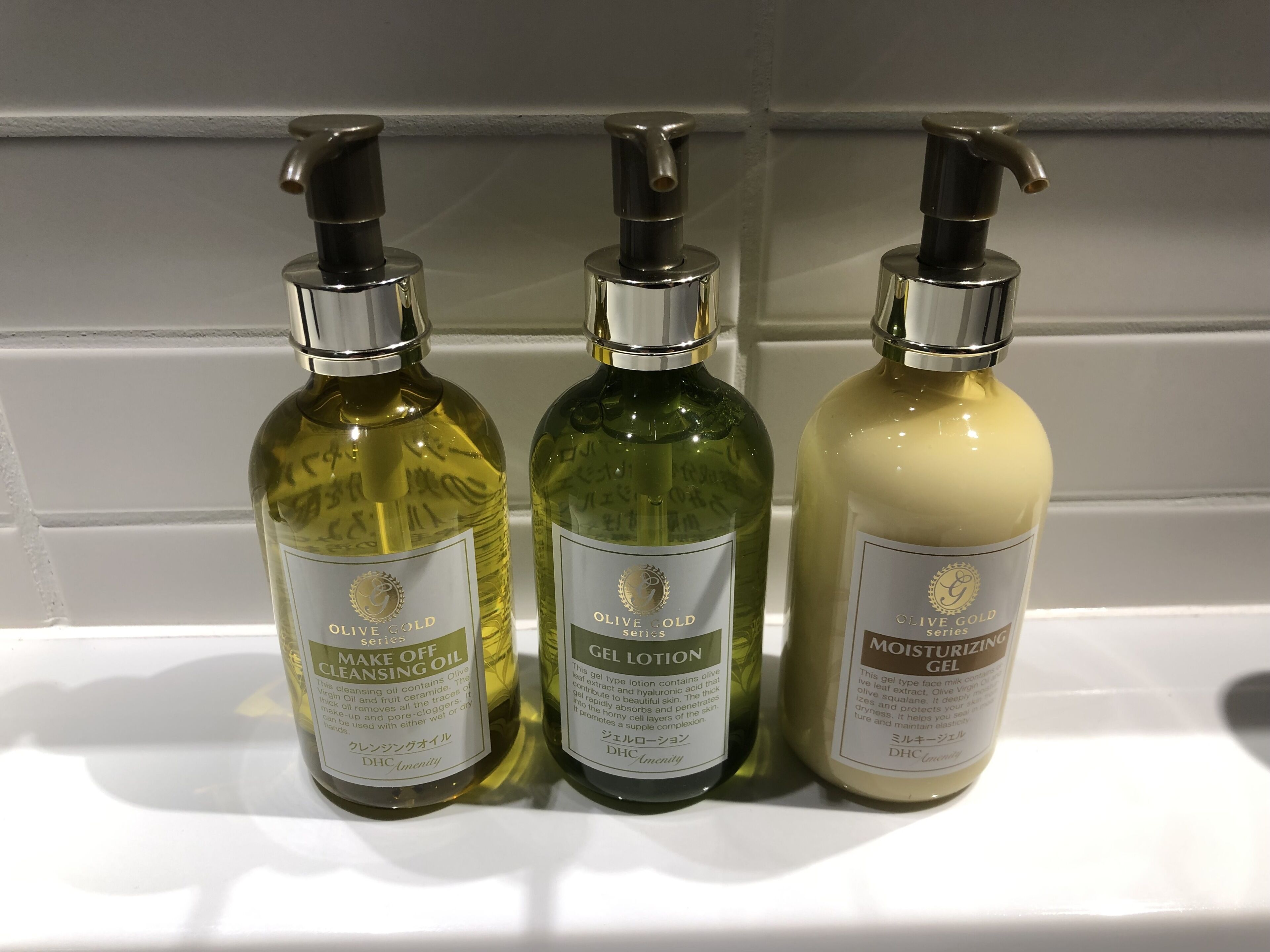 Three bottles of skincare products on a white shelf.