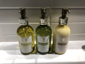 Three bottles of skincare products on a white shelf.