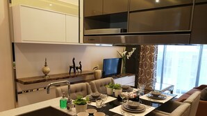 Een moderne keuken met een centraal eiland, inbouwapparatuur en een eethoek met zitplaatsen.