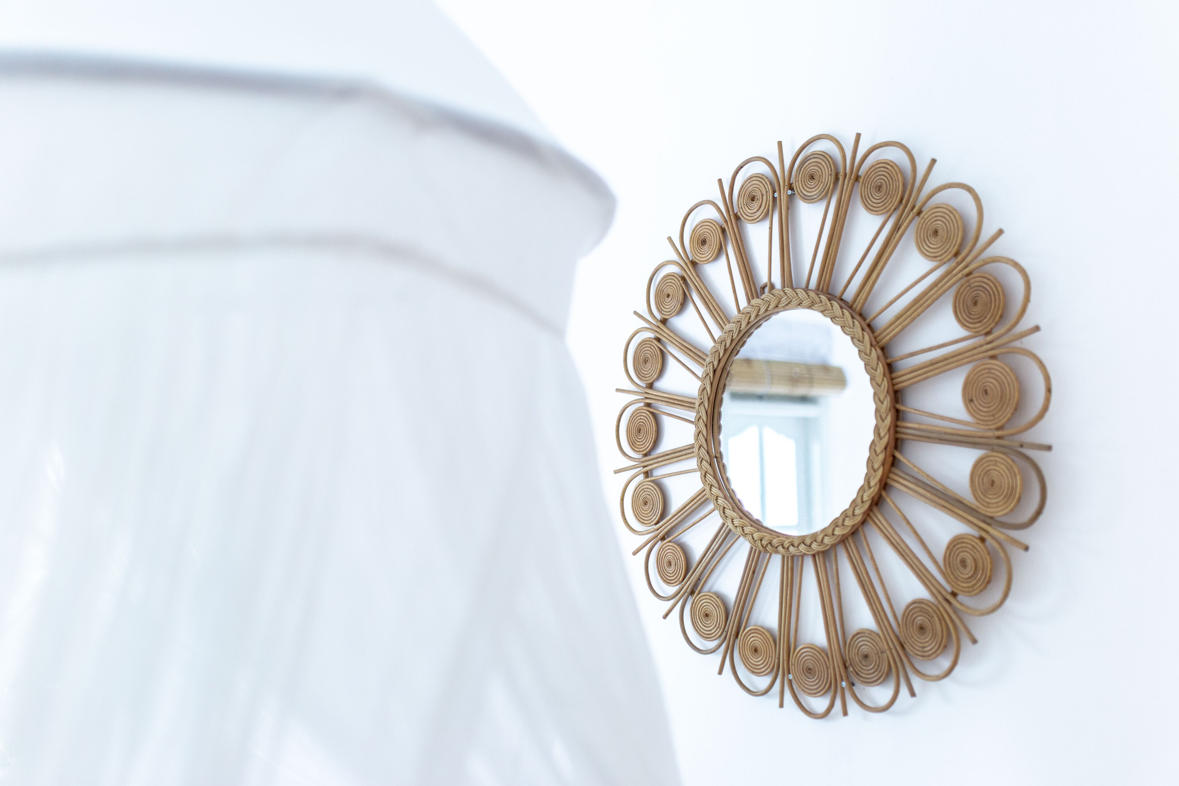 A wall-mounted decorative mirror with a sunburst design.