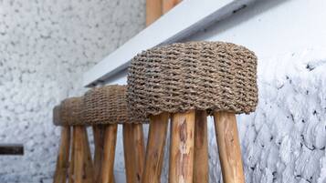 Una hilera de taburetes de madera con asientos de mimbre.
