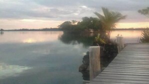 A wooden dock extending into calm water with a cloudy sky above. - Serah's Lagoon Hideaway (Auki)