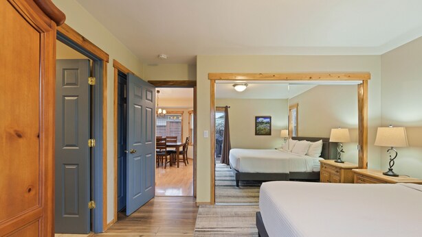 Een hotelkamer met een groot bed, een bureau met stoel en een kledingkast.
