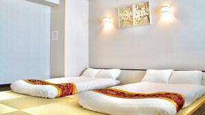 Une chambre d’hôtel avec deux lits, une grande fenêtre et une œuvre d’art accrochée au mur.