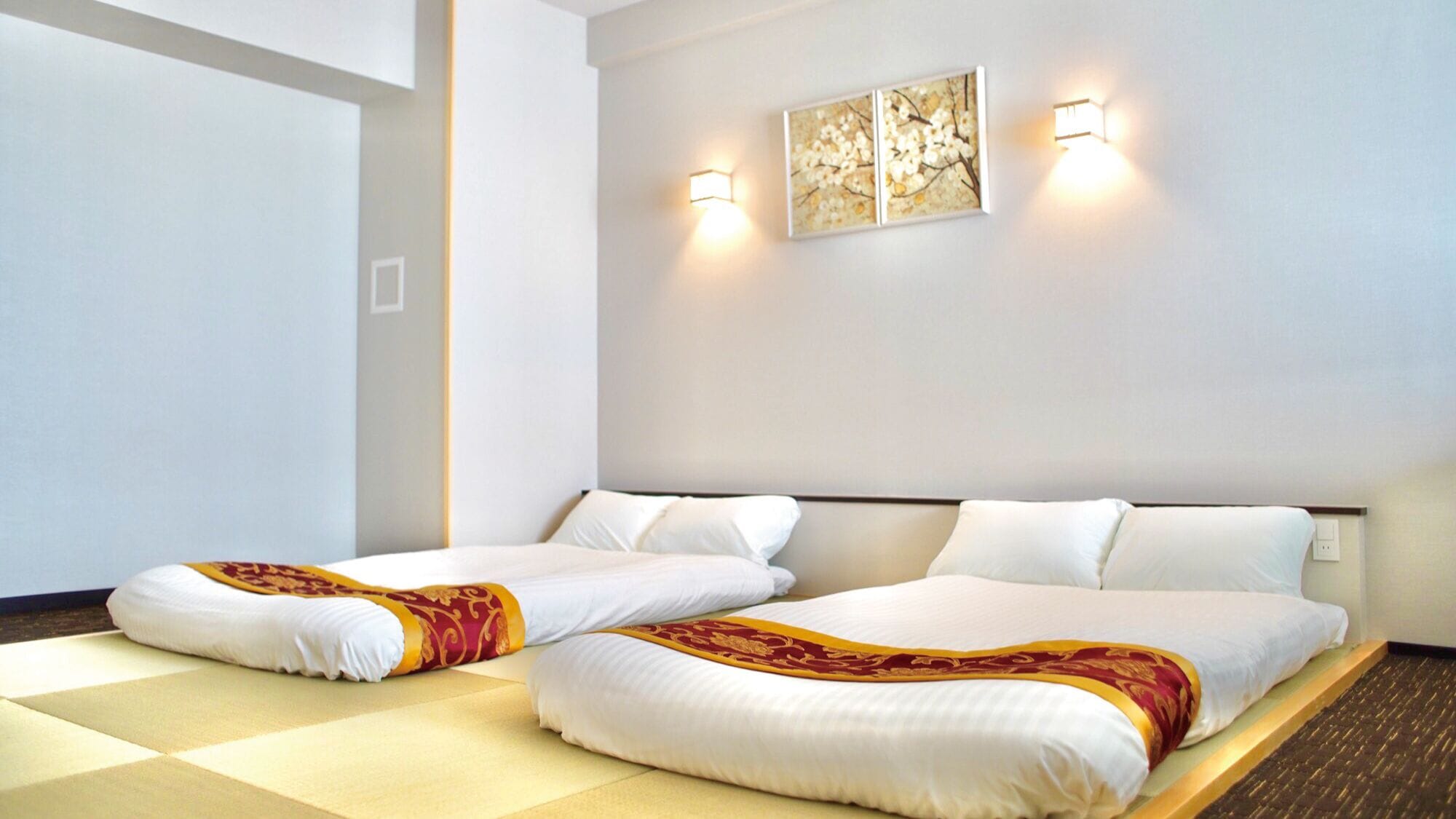 A hotel room with two beds, a large window, and wall-mounted artwork.
