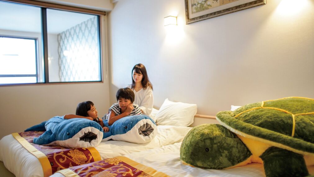 Una habitación con cama, ventana y una lámpara fijada a la pared.