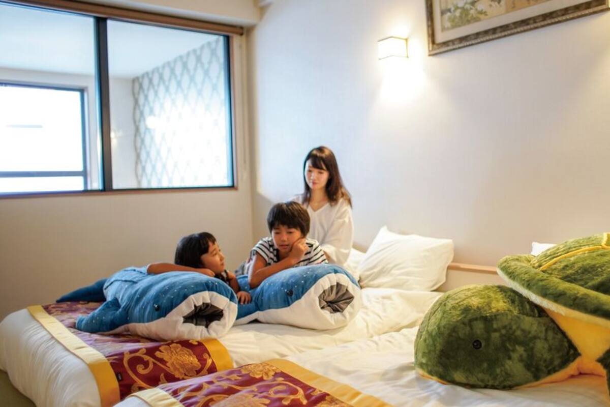 Een kamer met een bed, een raam en een wandlamp.